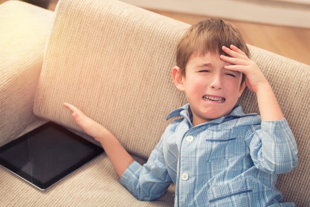 little boy throwing tantrum over a tablet