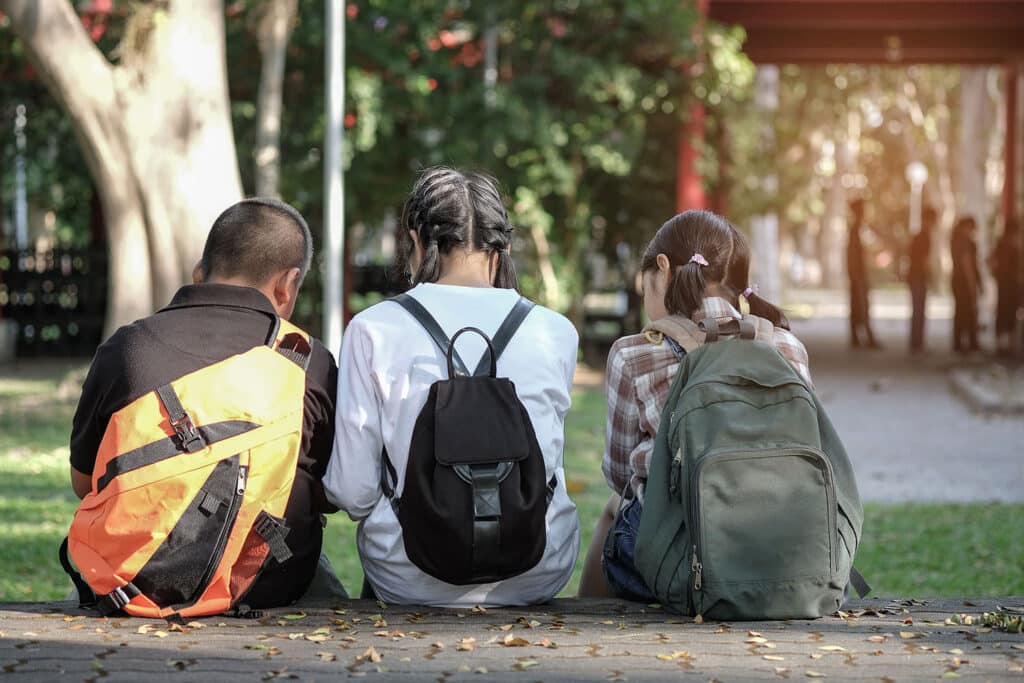 three young kids with backpacks