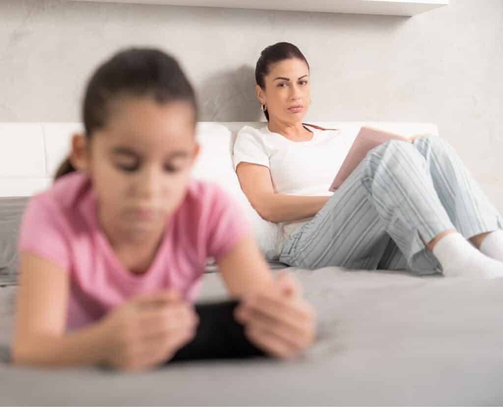 mother looking concerned at her daughter on her phone