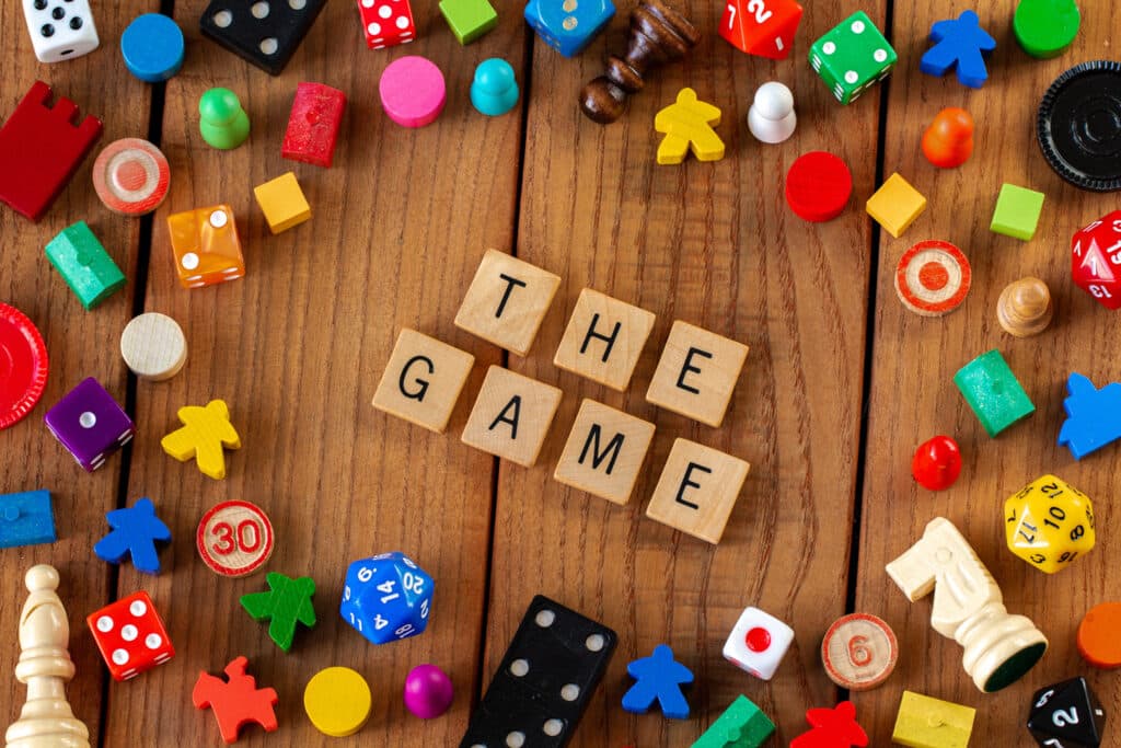 game pieces surrounding scrabble pieces that say the game