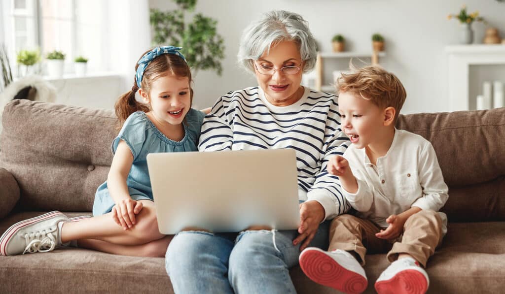 grandma on laptop with two grandkids