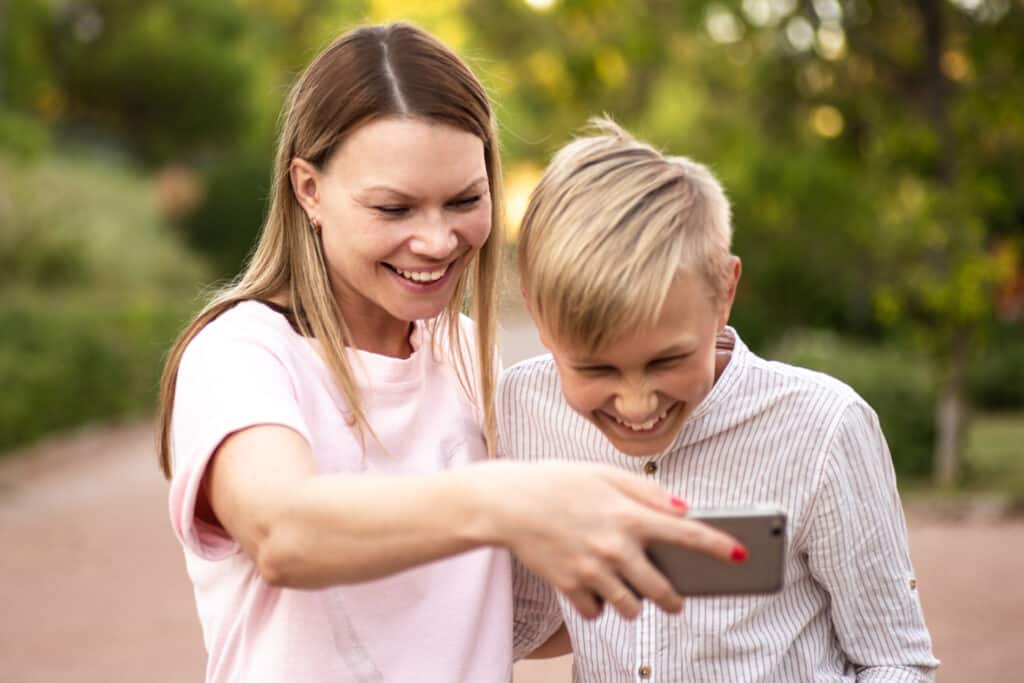 mother and son laughing at phone