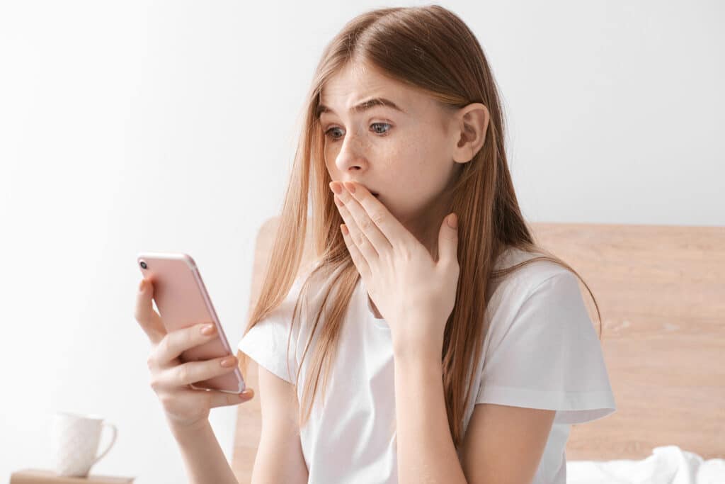 young girl looking at something shocking on cell phone