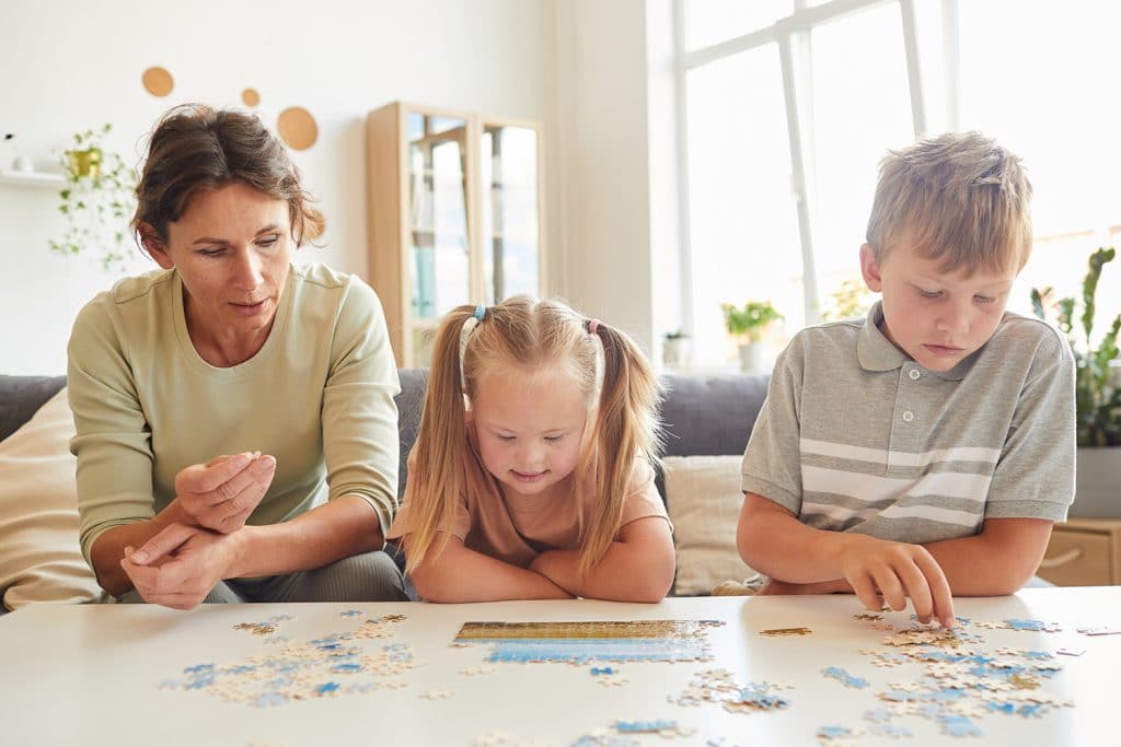 mother and two kids working on a puzzle together