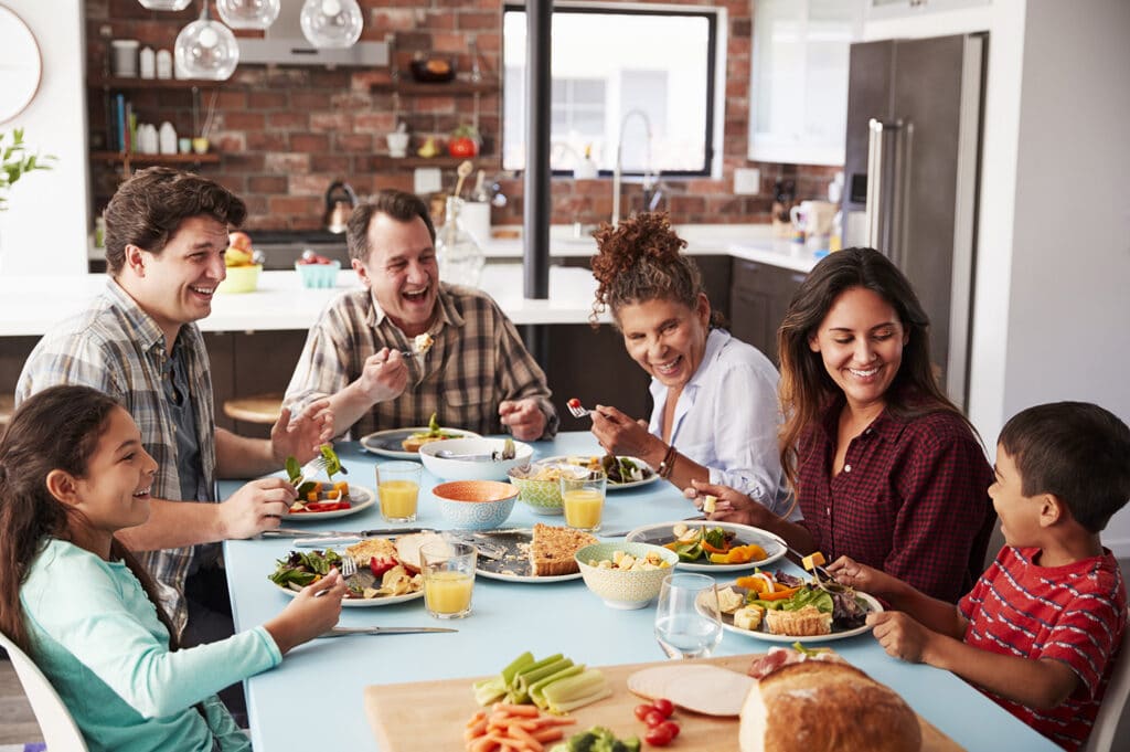 family sitting down for dinner together laughing