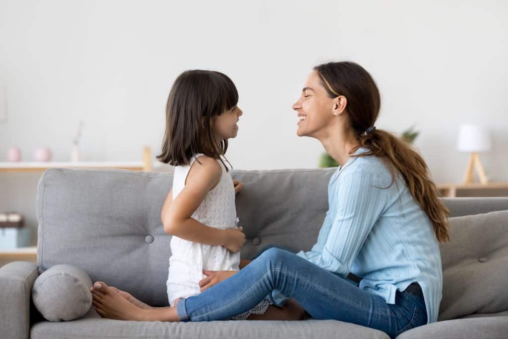 Mother and Daughter laughing together on couch