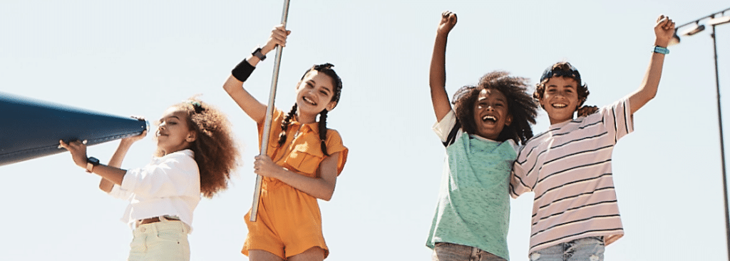 four happy tweens cheering